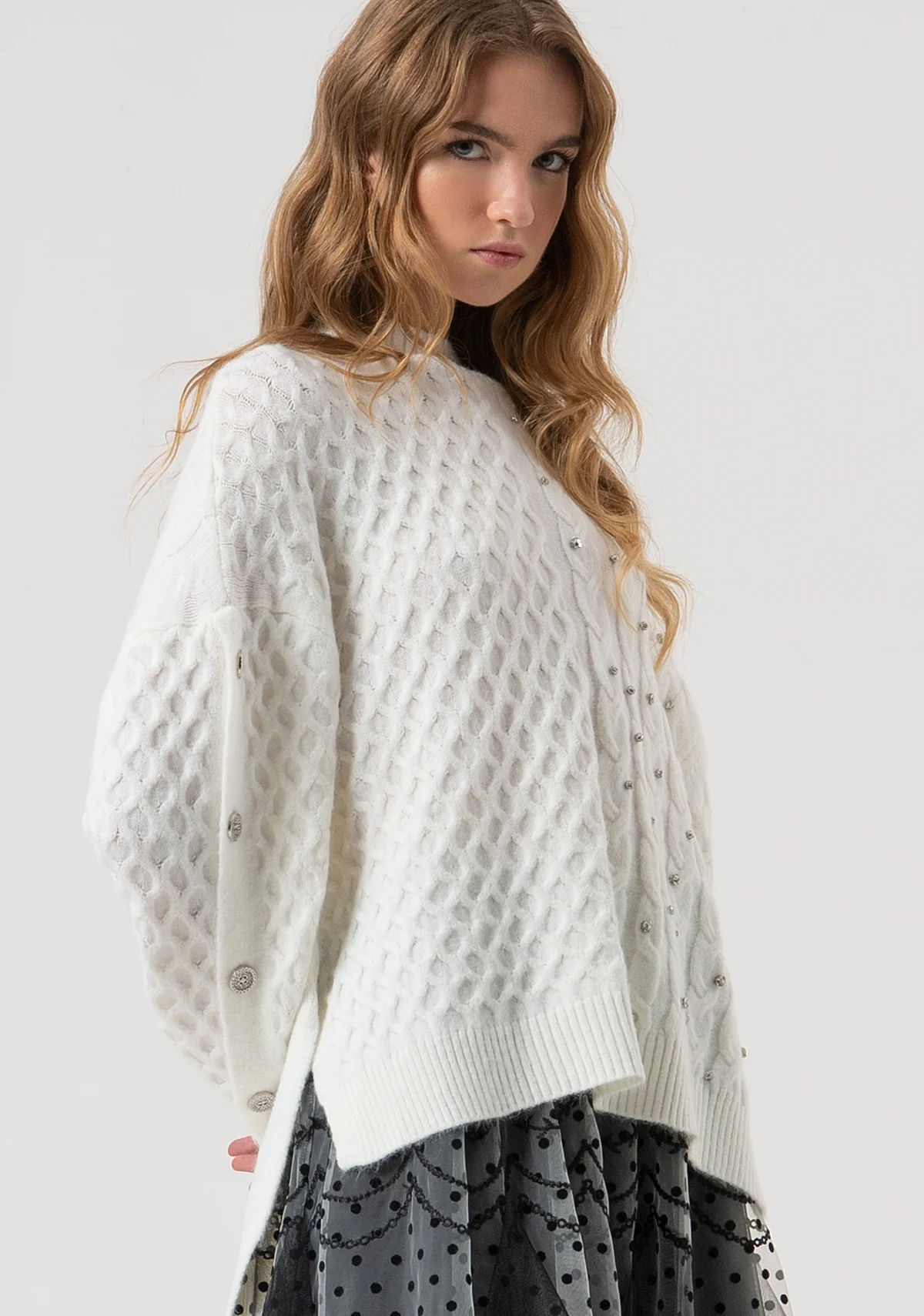 Jersey de punto ajustado con trenzas y aplicación de piedras brillantes.